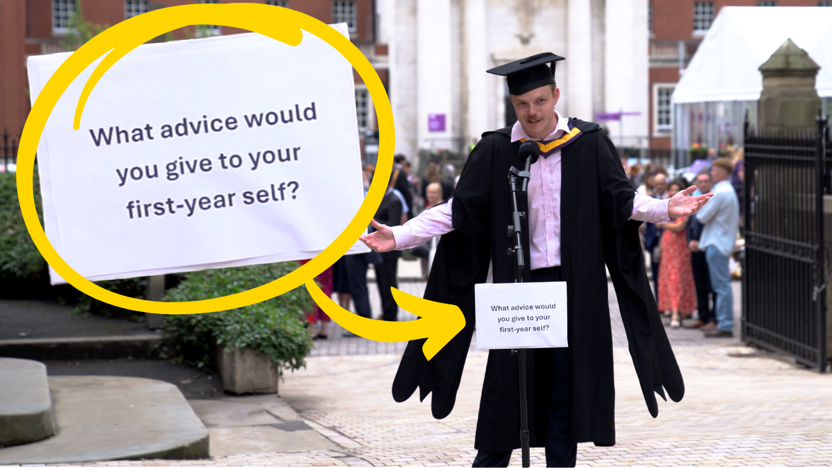 A graduating student standing in front of a microphone on campus. There is a sign on the microphone which reads "What advice would you give to your first-year self?"